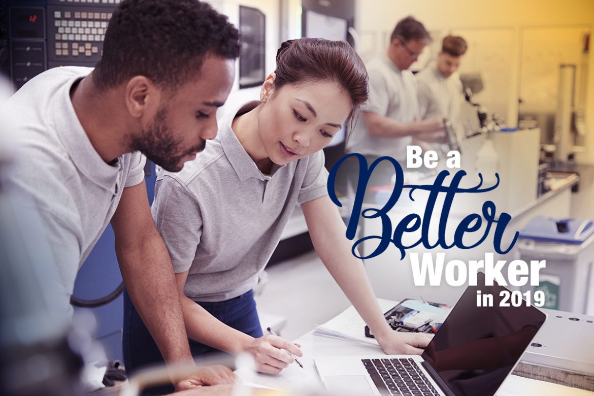 Young Asian woman and African American man working together on laptop in a warehouse facility