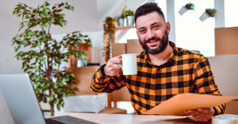Man sitting at his desk with a cup of coffee writing a cover letter